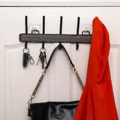 Purse, cloth, and keys are hanged on a black color wall mount hook hanger.