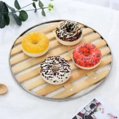 4 donuts are kept on a bamboo steamer plate