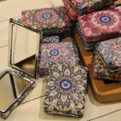 Travel pocket mirror is shown in different designs and patterns