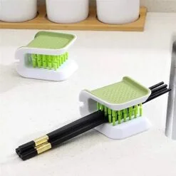 Double sided green color tool is being used as a chopstick cleaner.