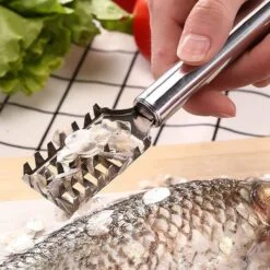 A woman is removing fish's skin with the help of stainless steel fish scraper