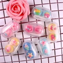 Fancy contact lens case is showcased in different colors and patterns besides a pink color flower