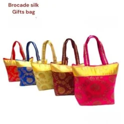 Printed hand bag is presented in a magenta, brown, golden, blue, and red color