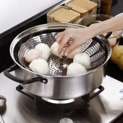 A woman is preparing momos using collapsible steamer basket