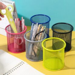 Round mesh pen organizer is shown in 5 different colors on a desk besides a diary. Scissor and pen pencils are kept in pink color mesh pen organzier. Pencils and specs are kept in blue color mesh pen organizer.