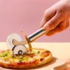 Chef is cutting pizza using dual wheel pizza cutter.