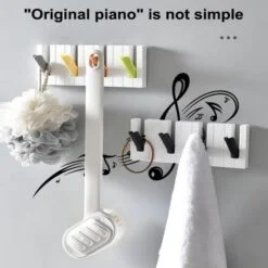 Shower sponge and long handle sponge is mounted on a multicolor piano hook & towel is hanged on a black & white piano hook.