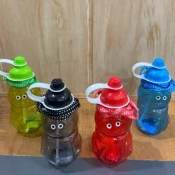 Fancy water bottle with straw is presented on a desk in green, blue, red, and black color.