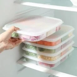 5 compartment food containers are placed on one another in refrigerator