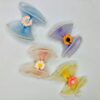 Flower design hair clip is presented in blue, pink, yellow, and purple color.