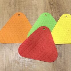 Orange, green, yellow, and red hot pot mats placed on a wooden table.