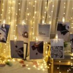 A photo wall illuminated by the warm glow of the LED string lights, creating a cozy and inviting ambiance.