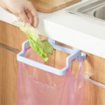 Kitchen Interior with Garbage Bag Napkin Hanger Installed and a person throwing garbage in bag.