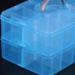 Two-layer, 20-grid storage organizer box made of clear plastic with a random color snap-shut lid.