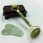 A close-up view of the jade facial roller, showcasing the smooth jade stone and dual-sized rollers for targeted massage.