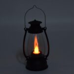 Warm Ambiance: LED Lantern & Tealight Candle Set in Action A glowing LED lantern and two realistic flameless tealight candles creating a warm and inviting atmosphere on a table.