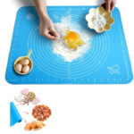 Multifunctional Versatility: Silicone Baking Sheet & Fondant Rolling Mat Set A large, rectangular silicone baking sheet displayed next to a smooth silicone fondant rolling mat with measurement markings.