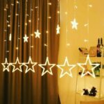 A strand of 6-Big-6-Small Star LED String Lights draped across a wall, casting a warm and inviting glow. The combination of big and small stars creates a whimsical atmosphere.