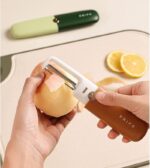 The 2-in-1 peeler and knife being used to peel an apple, highlighting the straight-edge blade gliding effortlessly through the skin.