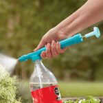 Manual Watering Device Spray A person holding a handheld manual watering device spray with a comfortable grip, spraying water onto a potted plant.