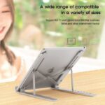 A person using a laptop on an adjustable aluminum laptop stand, with the stand positioned at an ergonomic angle for comfortable typing. Better Price & Quality than Amazon.