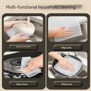 A person using a dishwashing cloth to wipe down a stainless steel countertop in the kitchen.