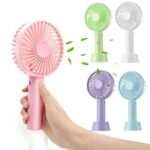 A person holding a small, rechargeable mini fan in their hand, with a refreshing breeze blowing on their face