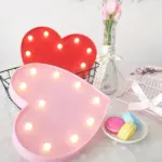 A heart-shaped LED light with a soft, pink or red glow, ideal for adding a touch of romance or whimsy to any space