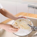 Effortless Cleaning: Using Oil-Absorbing Cloths for Kitchen Grease A person using an oil-absorbing cleaning cloth to wipe up a greasy mess on a kitchen surface. Cheaper than Amazon, Meesho, etc