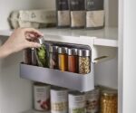 Wall-mounted under-shelf spice rack with six plastic bottles. Six spice bottles included with a wall-mounted under-shelf rack. Plastic spice rack with six bottles for under-shelf kitchen cabinet storage. Space-saving spice organizer with six bottles for wall mounting under shelves.