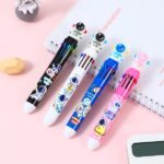 A close-up view of the astronaut ball pen, highlighting the click mechanism, the 10 colored pen tips, and any astronaut design details - stationery, school accessories for kids.